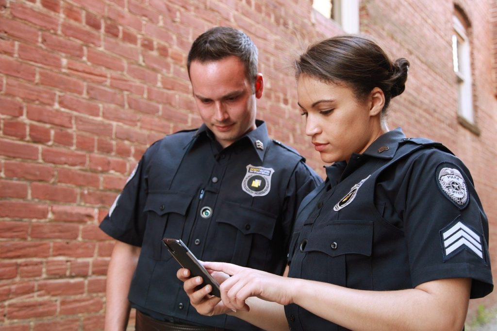 Police officers checking cell phone history of drivers